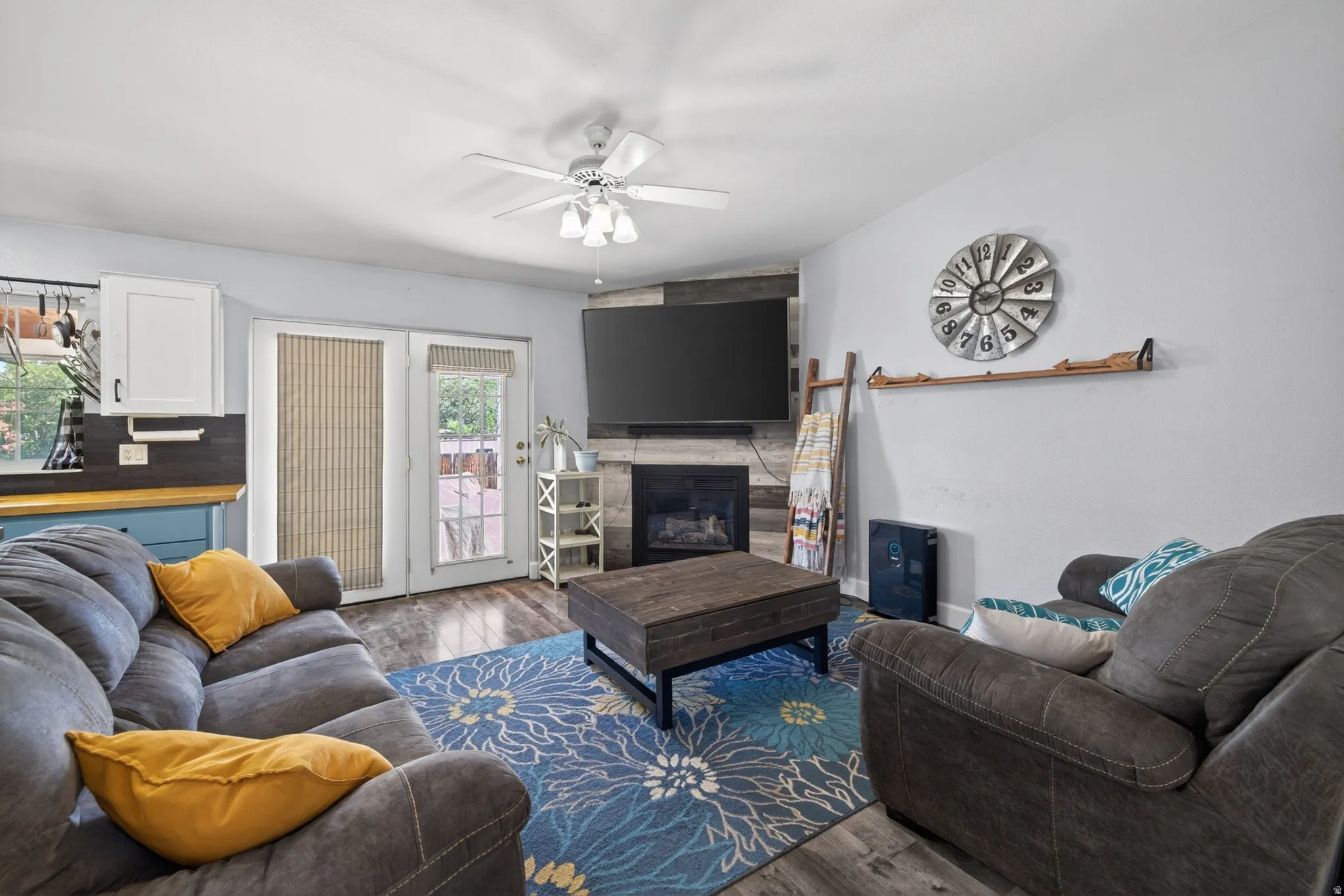 Living area featuring wood-finish flooring and a ceiling fan