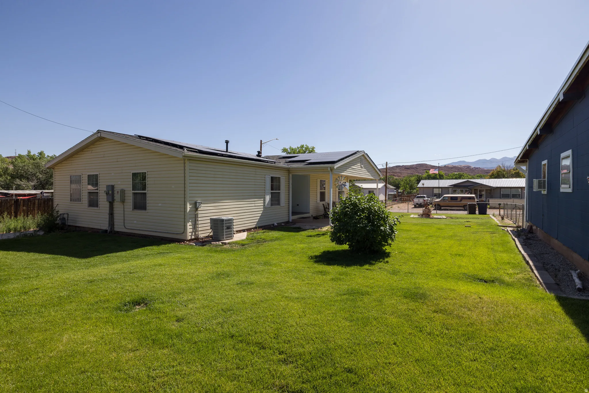 Expansive green lawn bordering a cream-colored siding residence