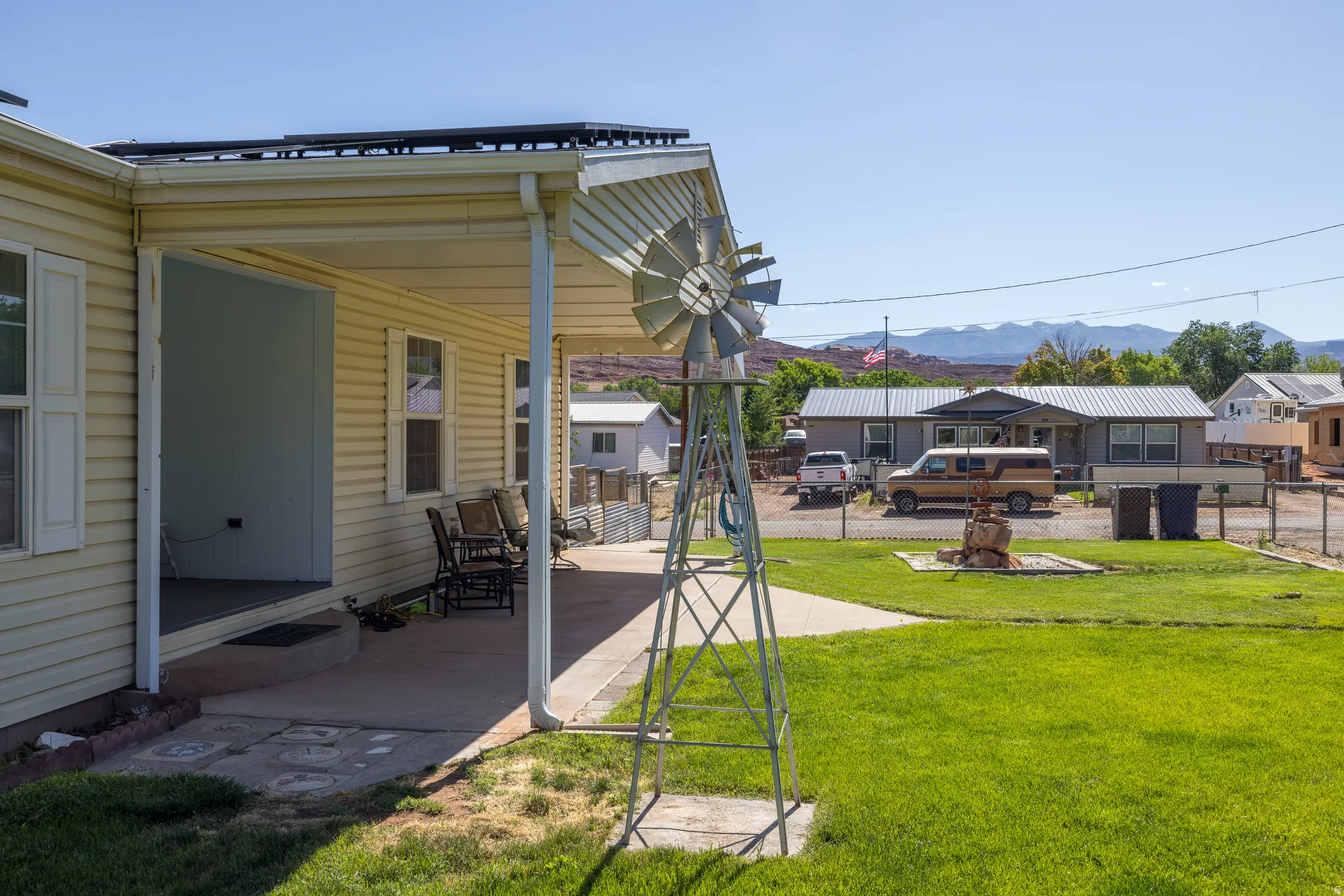 Residential property with a covered patio, solar panels, and a concrete walkway