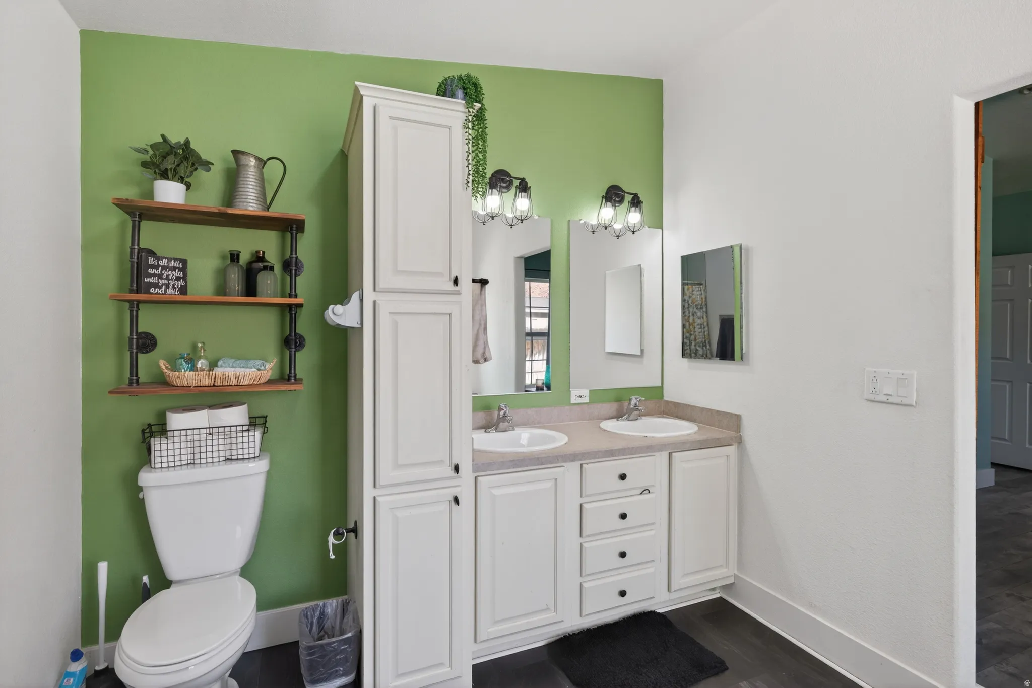 Bathroom vanity featuring dual sinks with individual mirrors, ample under-sink storage, and a tall built-in storage cabinet