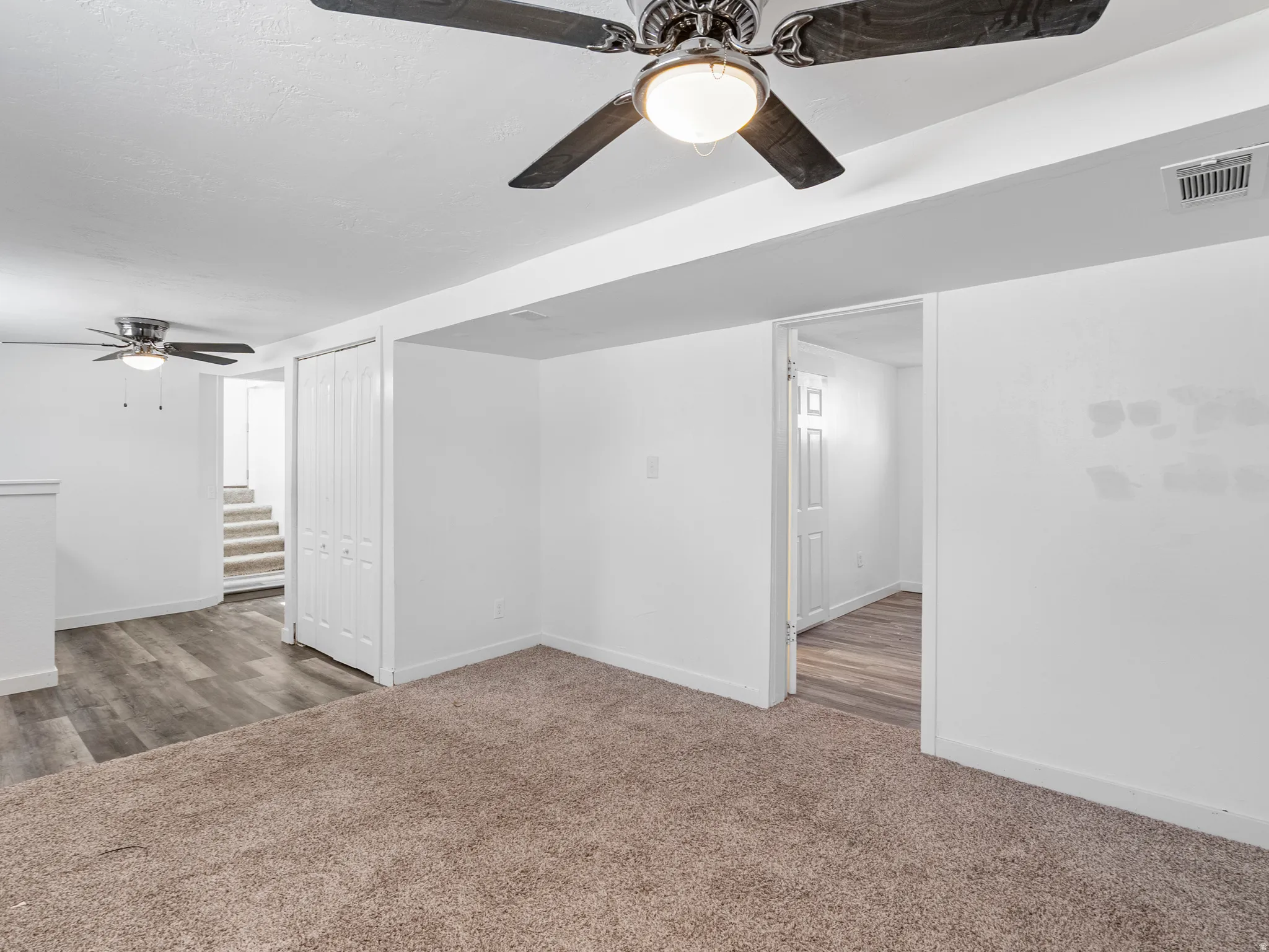Interior room featuring neutral carpeting and white walls