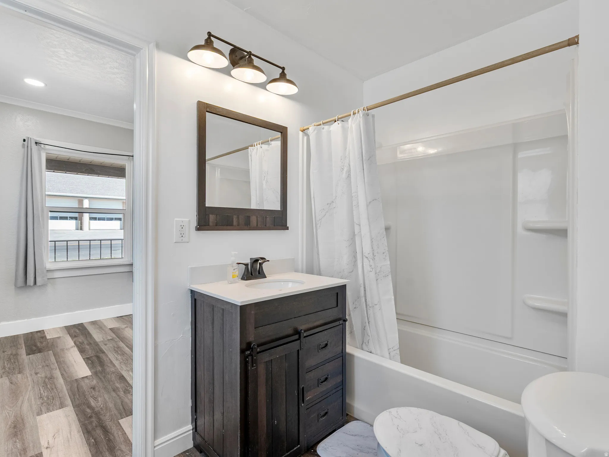 Bathroom featuring a single vanity with a dark wood-finish cabinet and a white countertop