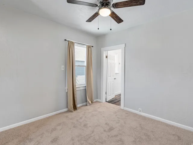 Bedroom featuring wall-to-wall carpeting, light-toned wall paint, a window with blinds, and a ceiling fan with integrated lighting