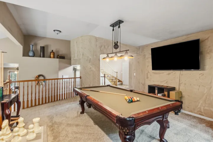 Carpeted loft area featuring a billiard table with a dedicated overhead light fixture