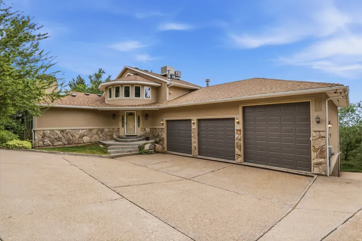Stucco and stone exterior featuring a prominent rounded bay window with multiple panes