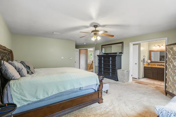 Bedroom featuring light green walls and plush carpeting