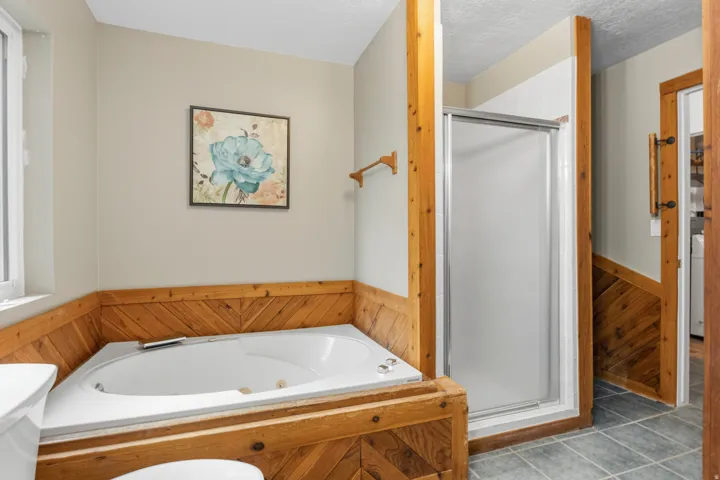 Corner jetted soaking tub featuring wood paneling