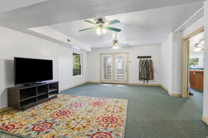 Spacious interior room featuring light-colored walls and green carpeting