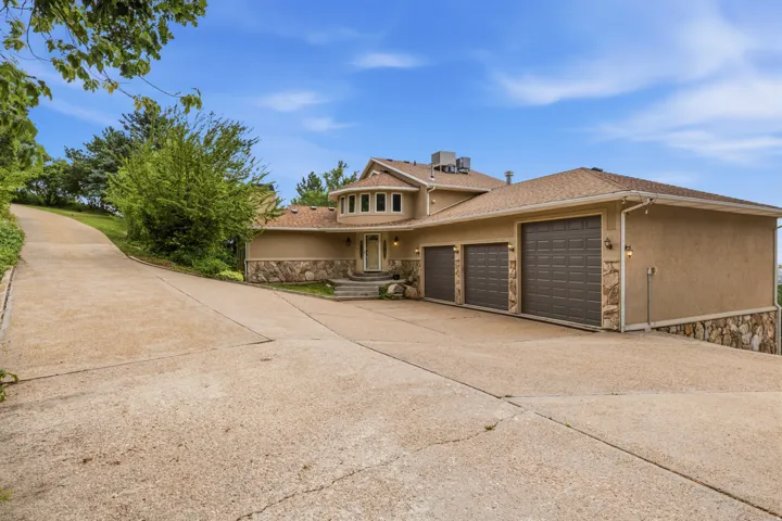 Stucco exterior with stone accents and a multi-level roofline