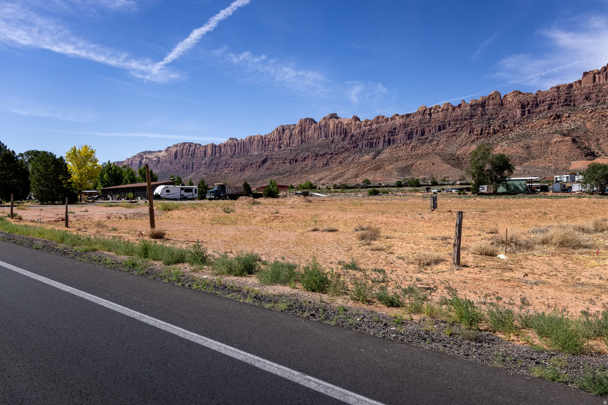 Expansive open land featuring natural vegetation and a rugged mountain backdrop