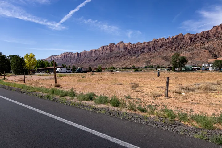 Expansive open land featuring natural vegetation and a rugged mountain backdrop