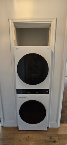 White stacked washer and dryer unit with black accents
