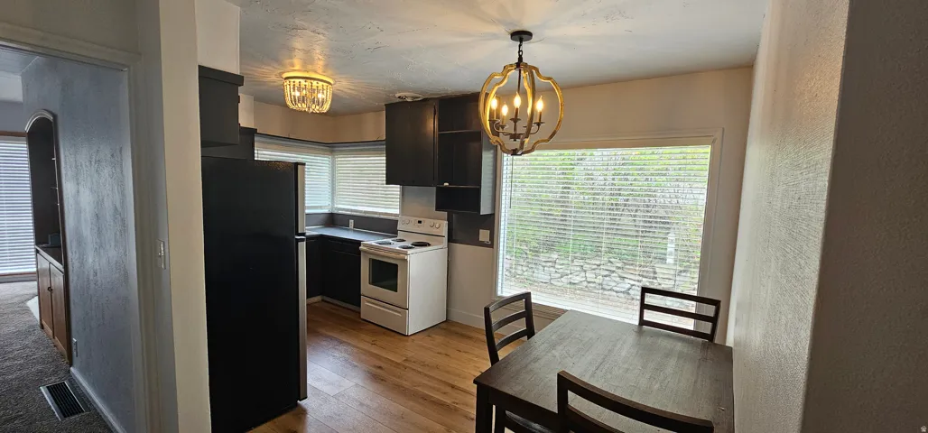Kitchen area featuring wood-finish flooring, dark cabinetry, and a large window