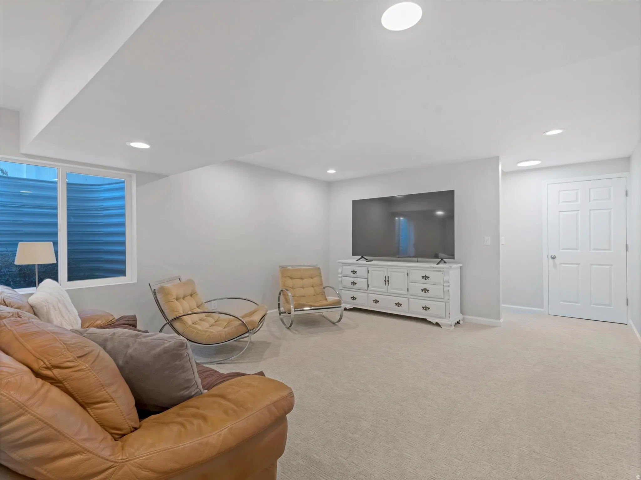 Spacious finished lower level featuring recessed lighting, a window well, and light-toned carpeting