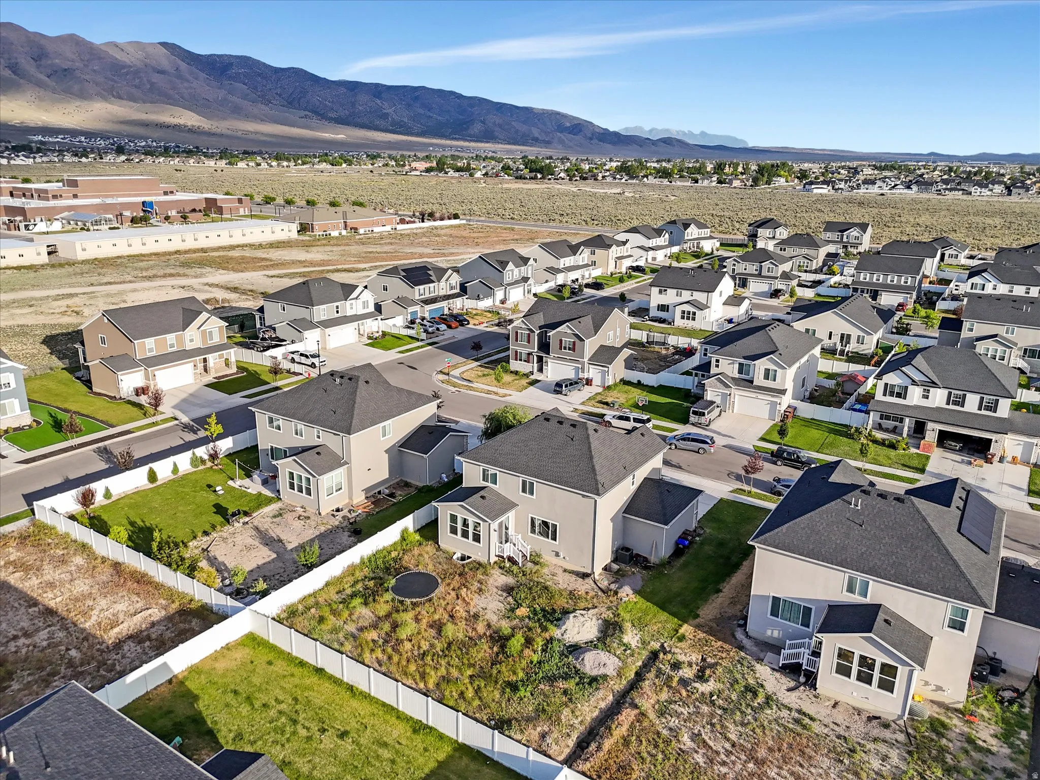 Aerial perspective showcasing a residential community with contemporary homes, featuring varied architectural styles and dark-shingle roofs