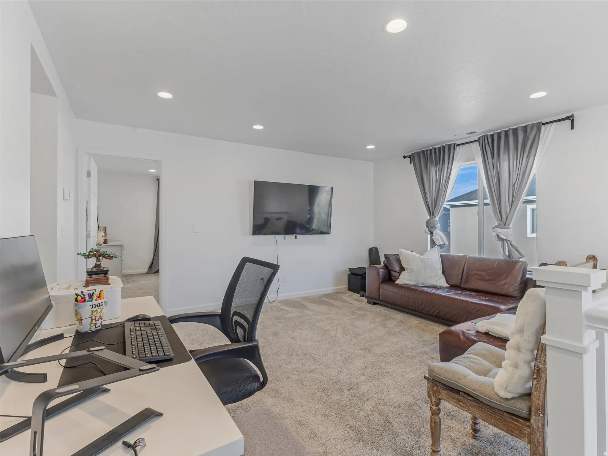 Carpeted living space with recessed lighting and neutral wall finishes