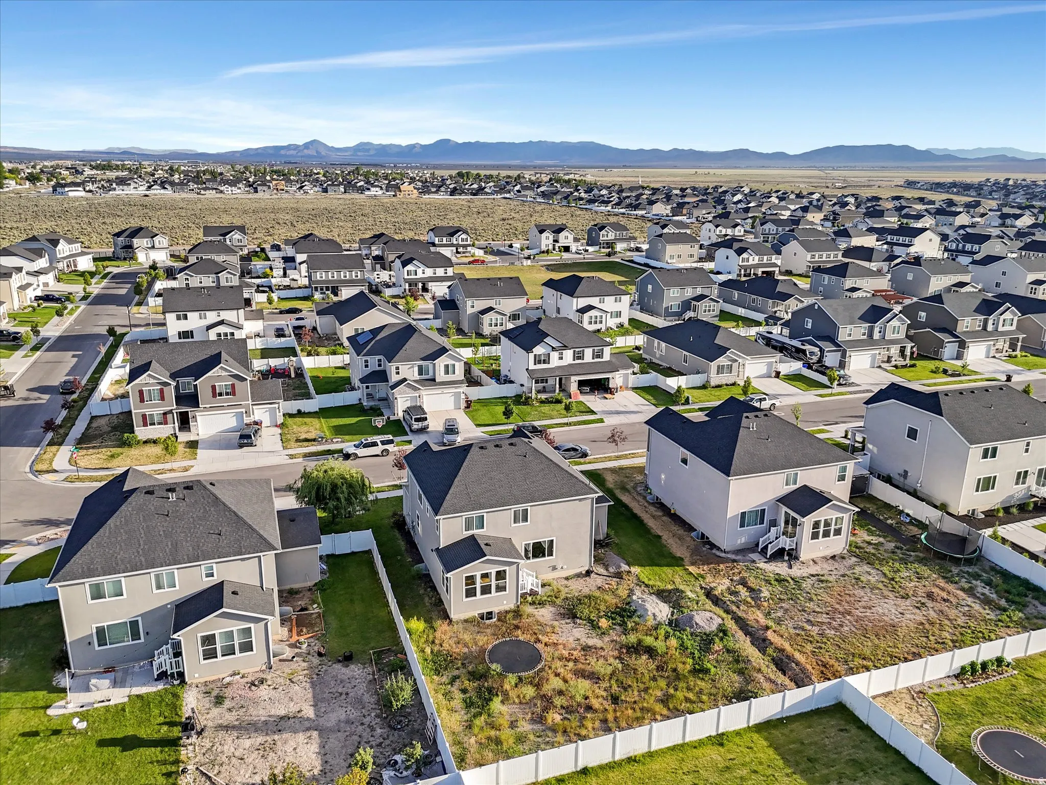 Expansive neighborhood featuring a variety of contemporary homes with distinct architectural styles, dark shingle roofs, and light-colored siding