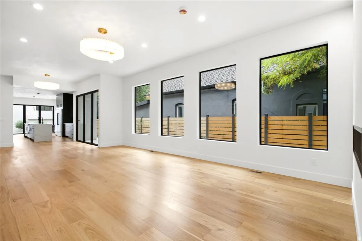 Spacious open-concept interior featuring light wood-finish flooring and recessed lighting