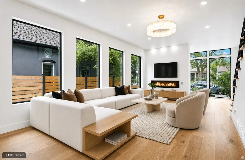 Hardwood flooring, recessed lighting, linear fireplace, contemporary chandelier, and large windows
