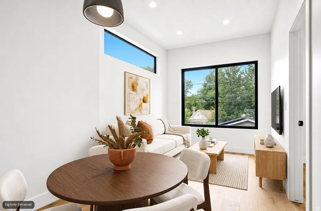 Open-concept living area featuring wood-finish flooring, recessed lighting, and a linear transom window