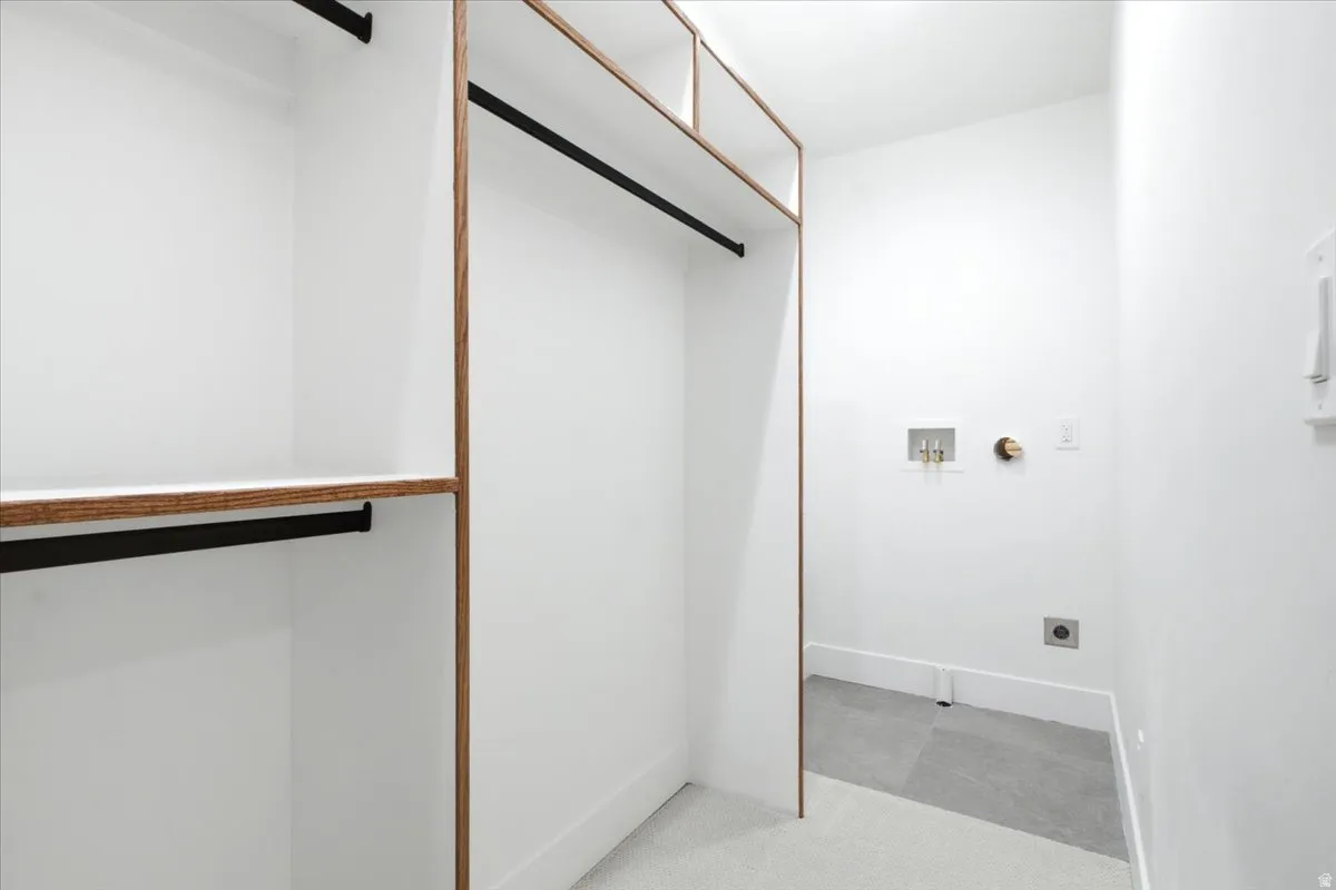 Primary Custom closet system featuring wood-finish framing and integrated shelving. Washer and dryer hookups