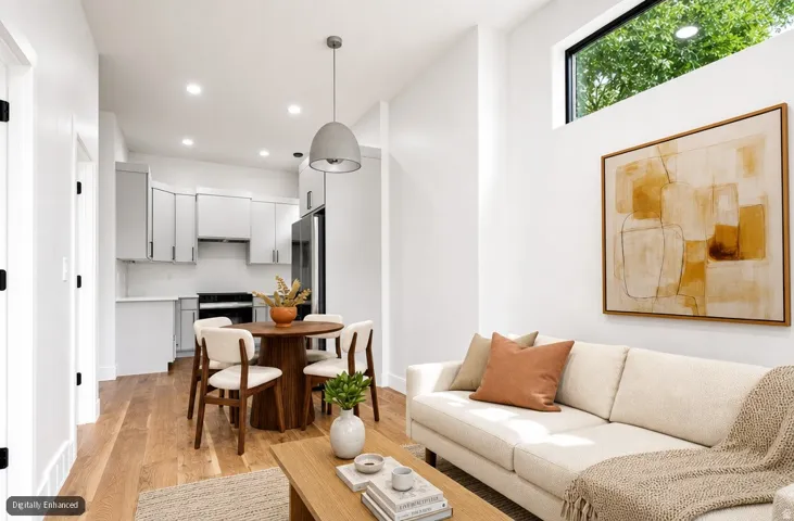 High ceilings with transom windows, wood-finish flooring, recessed lighting, white cabinetry, and stainless steel appliances