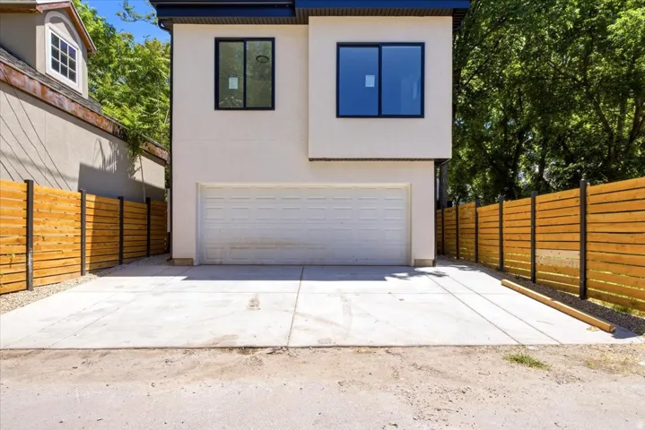 Modern exterior with smooth stucco finish, black-framed windows, and an integrated garage