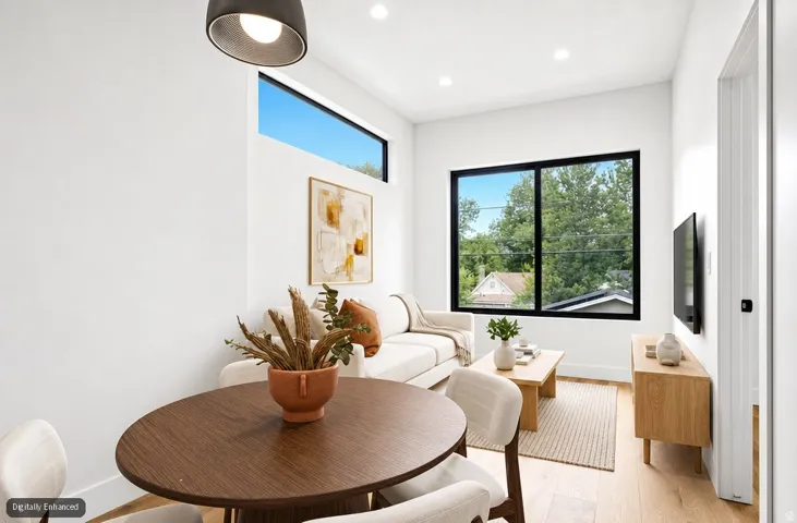 Open-concept living area featuring wood-finish flooring, recessed lighting, and a linear transom window