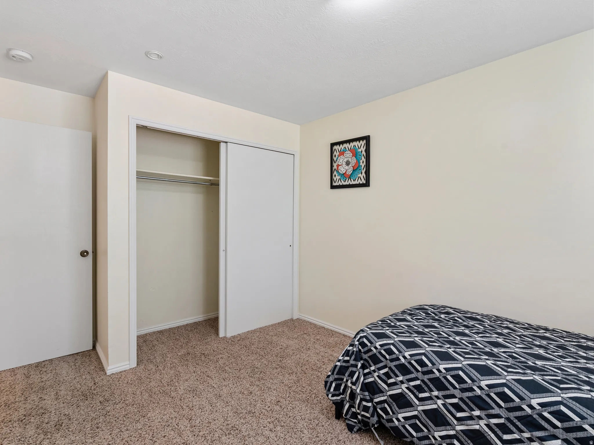 Room featuring neutral wall finishes and a built-in closet with sliding doors and a hanging rod