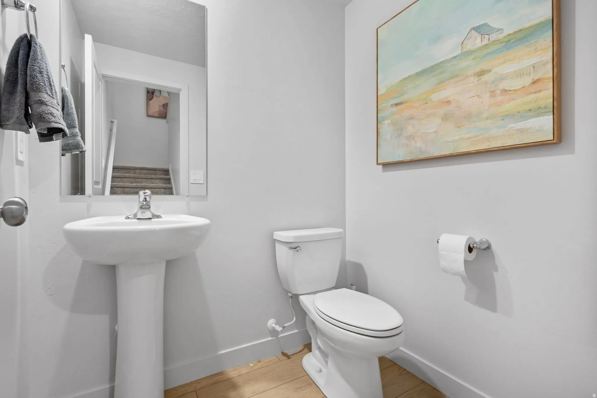 Pedestal sink with chrome faucet, complemented by a white toilet