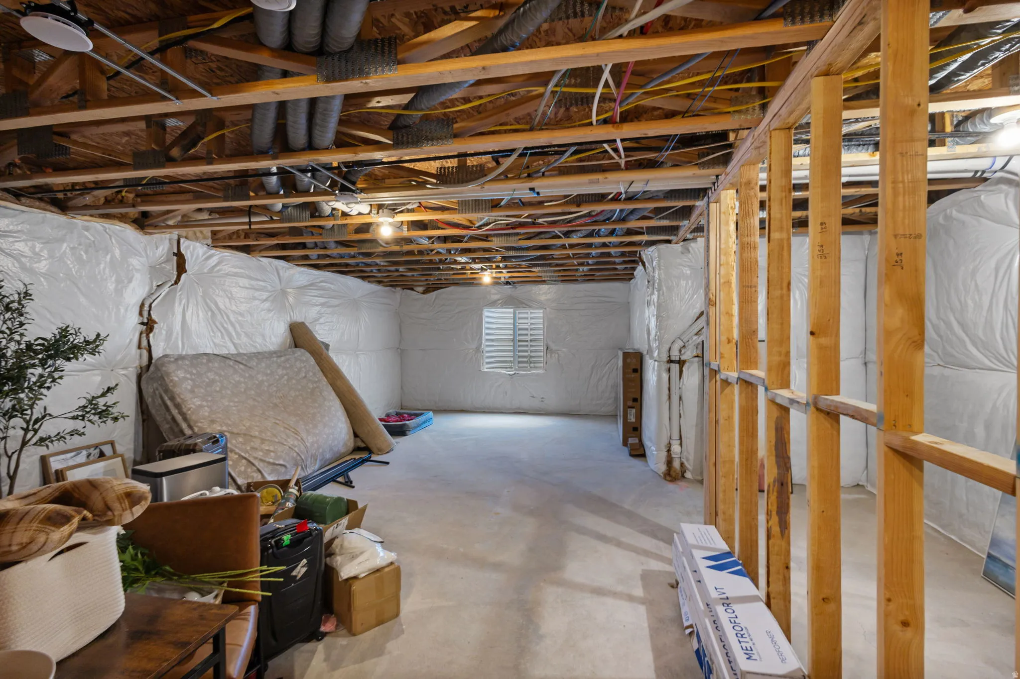 Unfinished basement with exposed ceiling joists and concrete flooring
