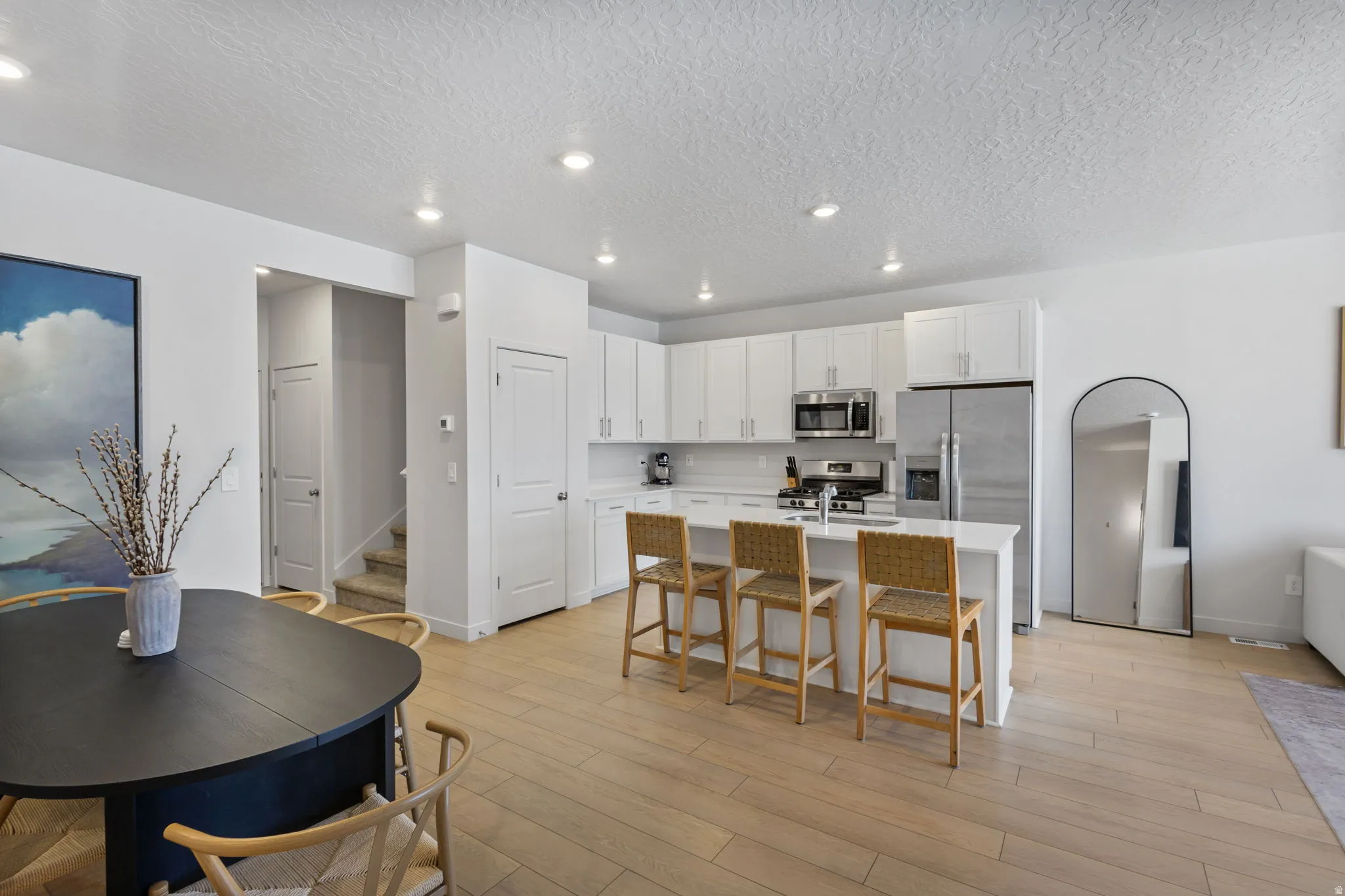 Open-concept kitchen and dining area featuring light wood-finish flooring