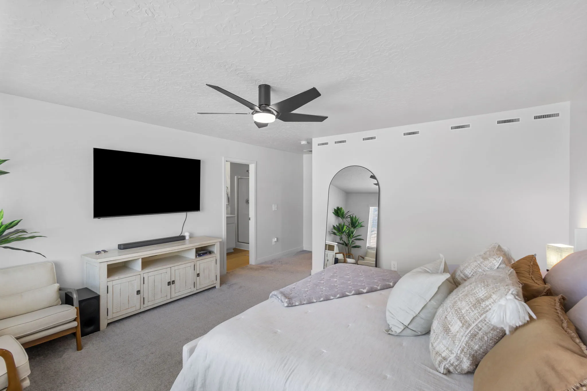 Carpeted room featuring a ceiling fan, white walls, and a recessed architectural detail