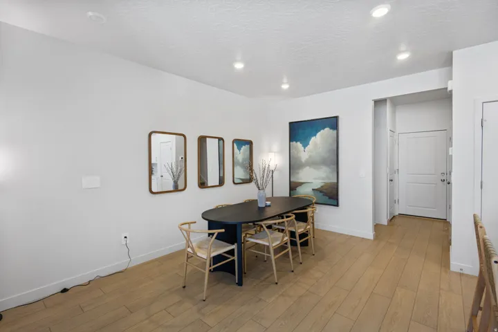 Bright interior space featuring light wood-finish flooring, recessed lighting, and a white paneled door