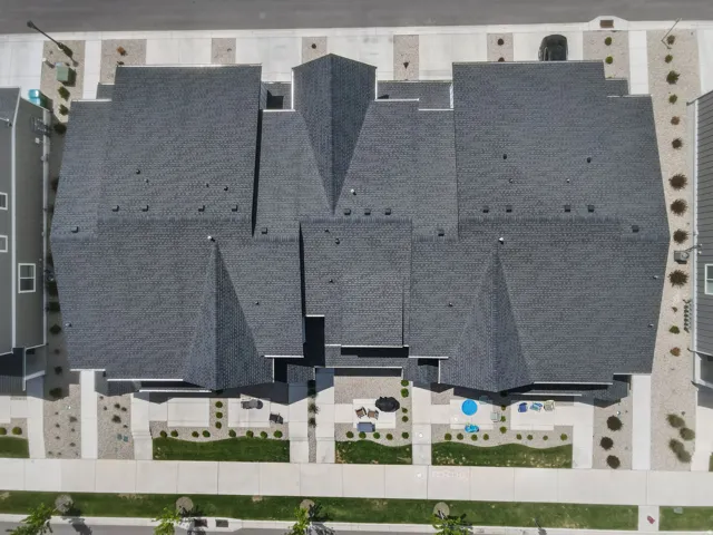 Aerial perspective showcasing multiple residential structures with dark shingle roofing