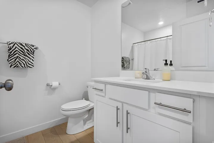 White vanity with a single sink, chrome faucet, and integrated countertop