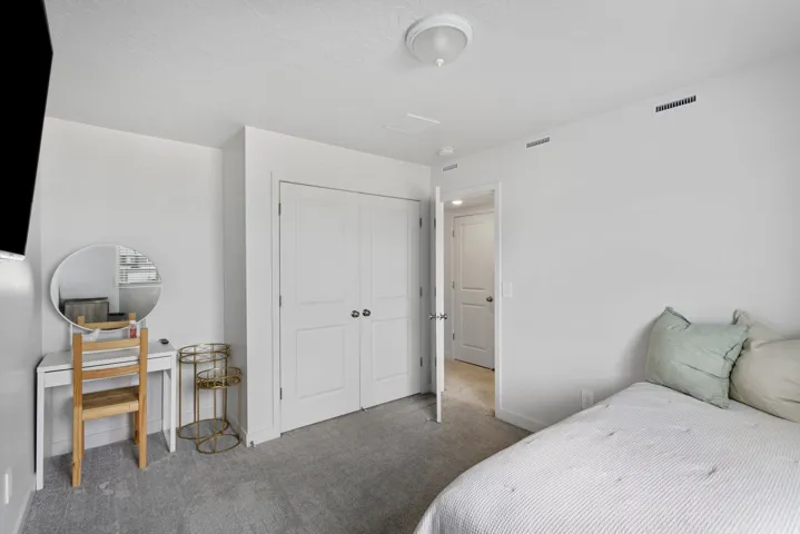 Bedroom with neutral carpeting and white walls