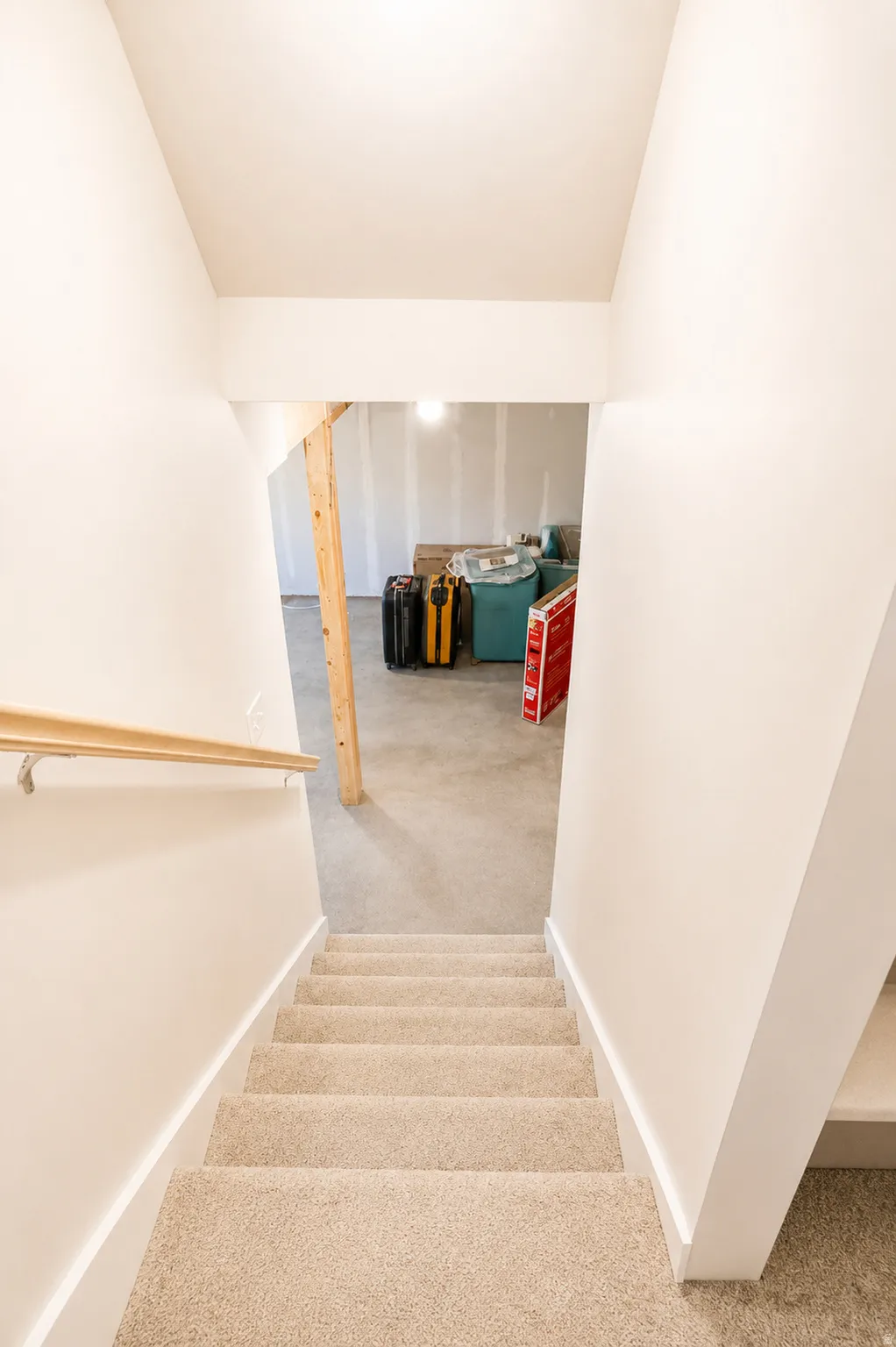 Carpeted staircase with light wood handrail