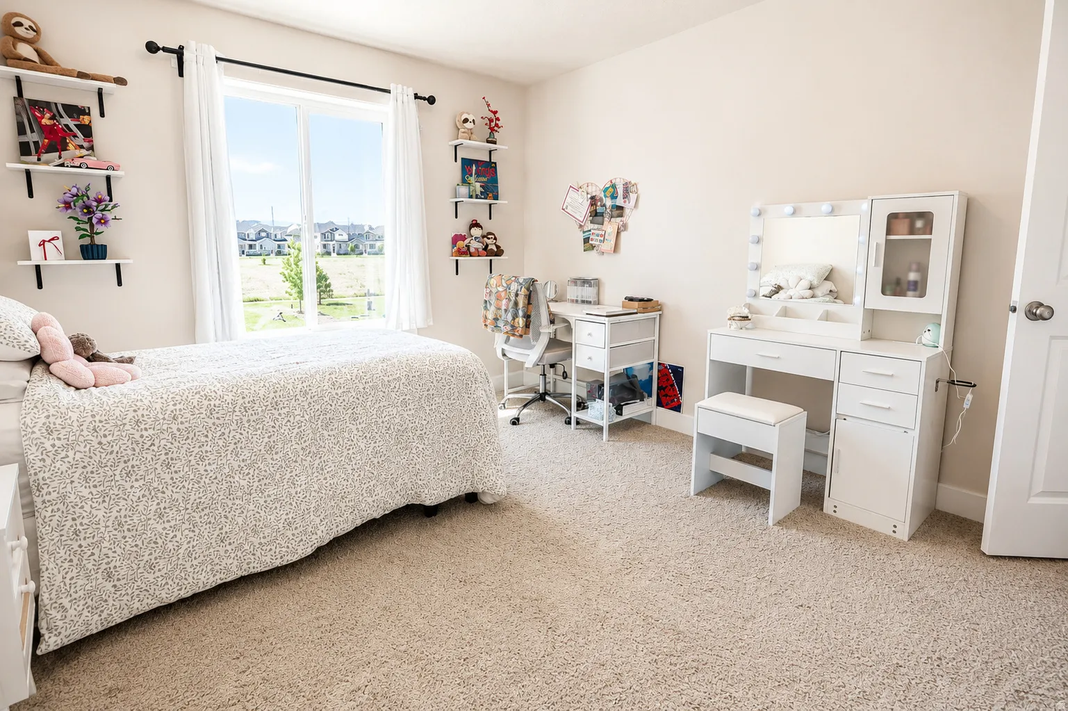 Wall-to-wall carpeted bedroom featuring a large window with white curtains, a neutral wall color, and white baseboards