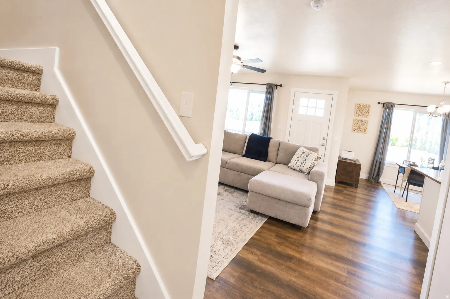 Staircase featuring carpeted treads and a white handrail