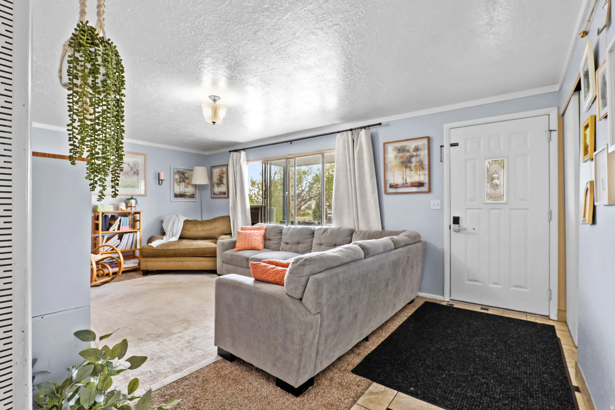 Living space featuring light blue walls, a front entry door with decorative glass insert, and a built-in bookshelf