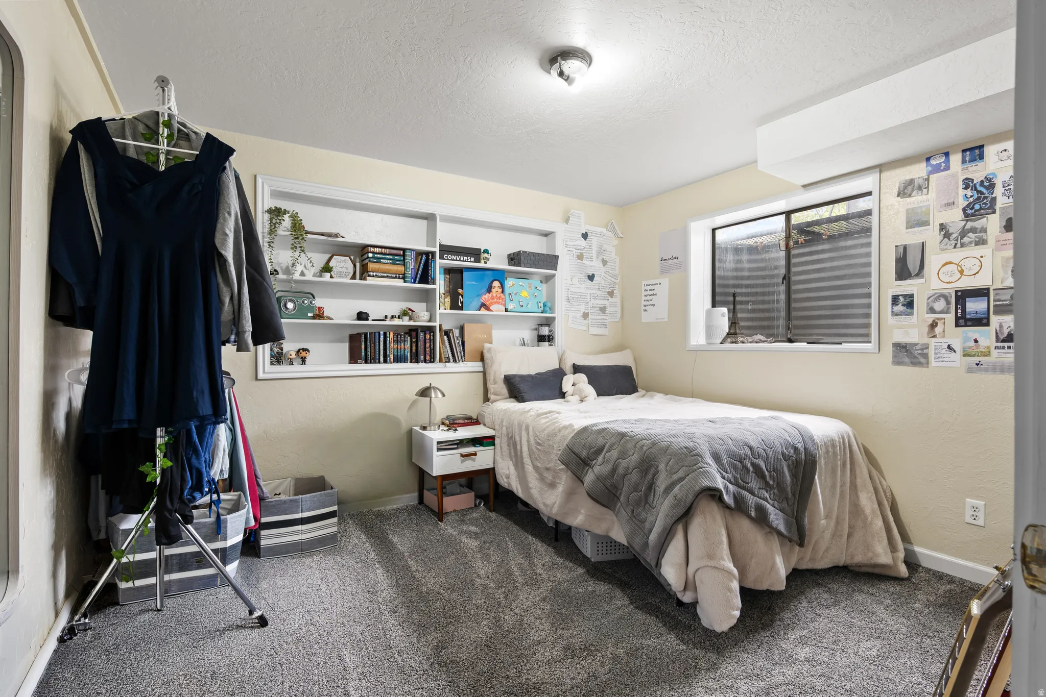 Carpeted room featuring built-in shelving, a recessed window, and neutral wall tones