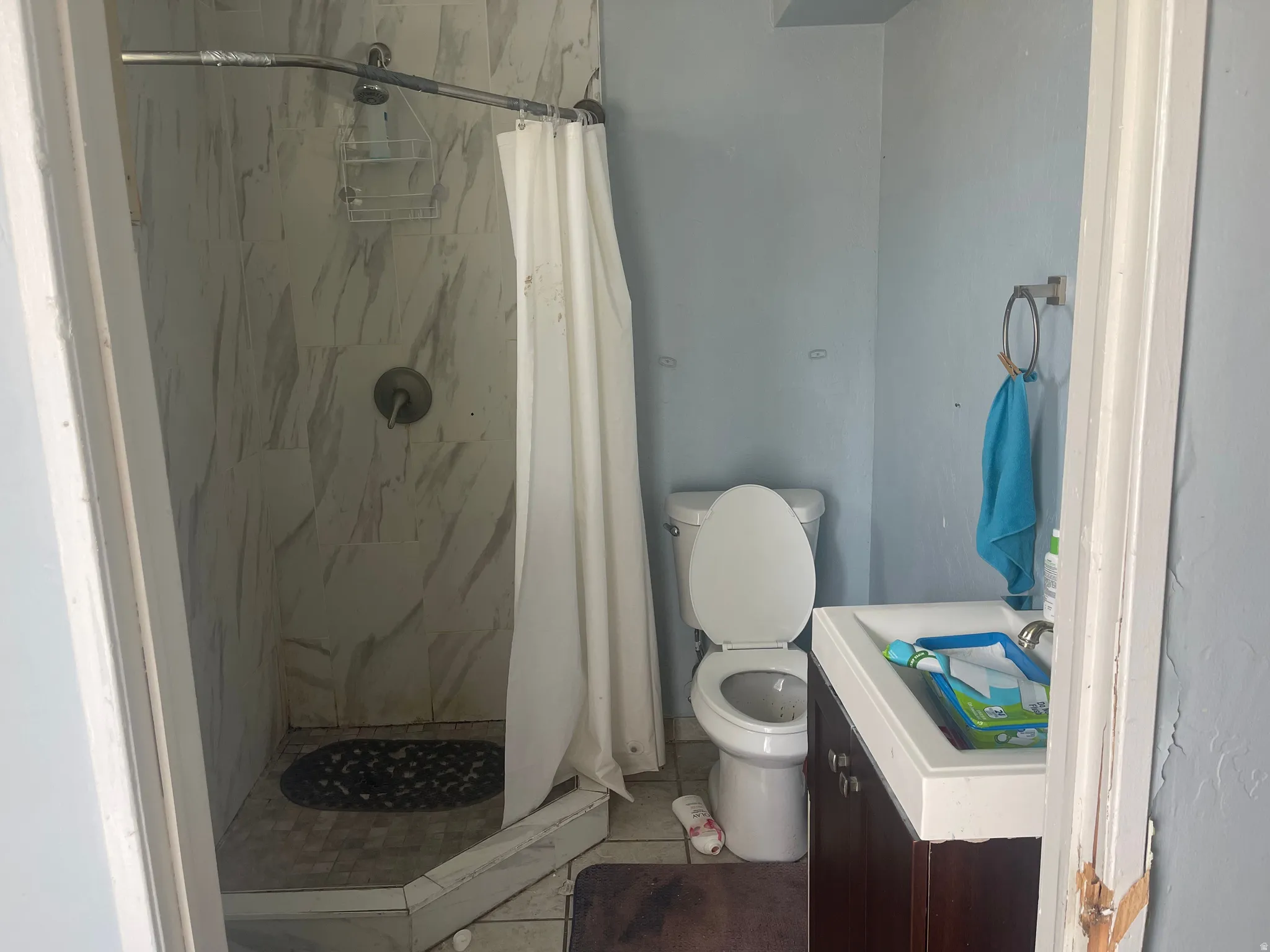 Tiled shower enclosure featuring a curved shower rod and wall-mounted fixtures
