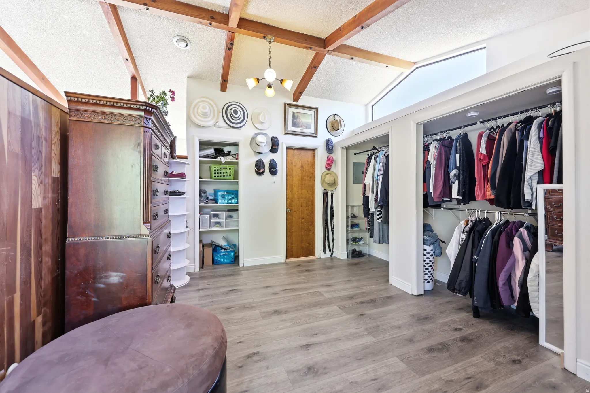 Vaulted ceiling with exposed wood beams, light wood-finish flooring, recessed lighting, and clerestory window