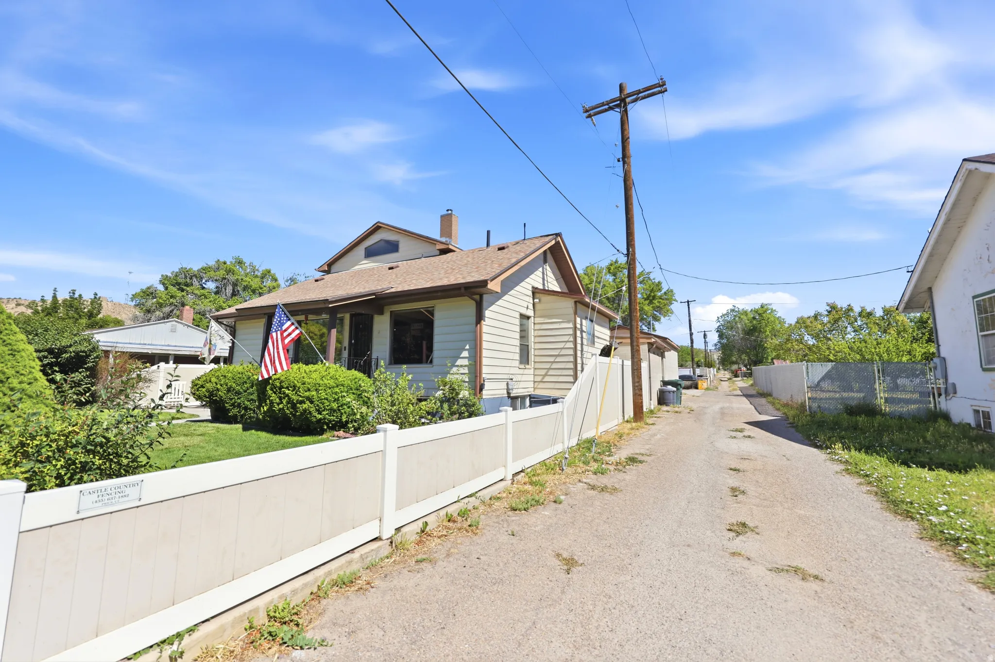 Single-story residence with light-colored siding and a brown shingle roof