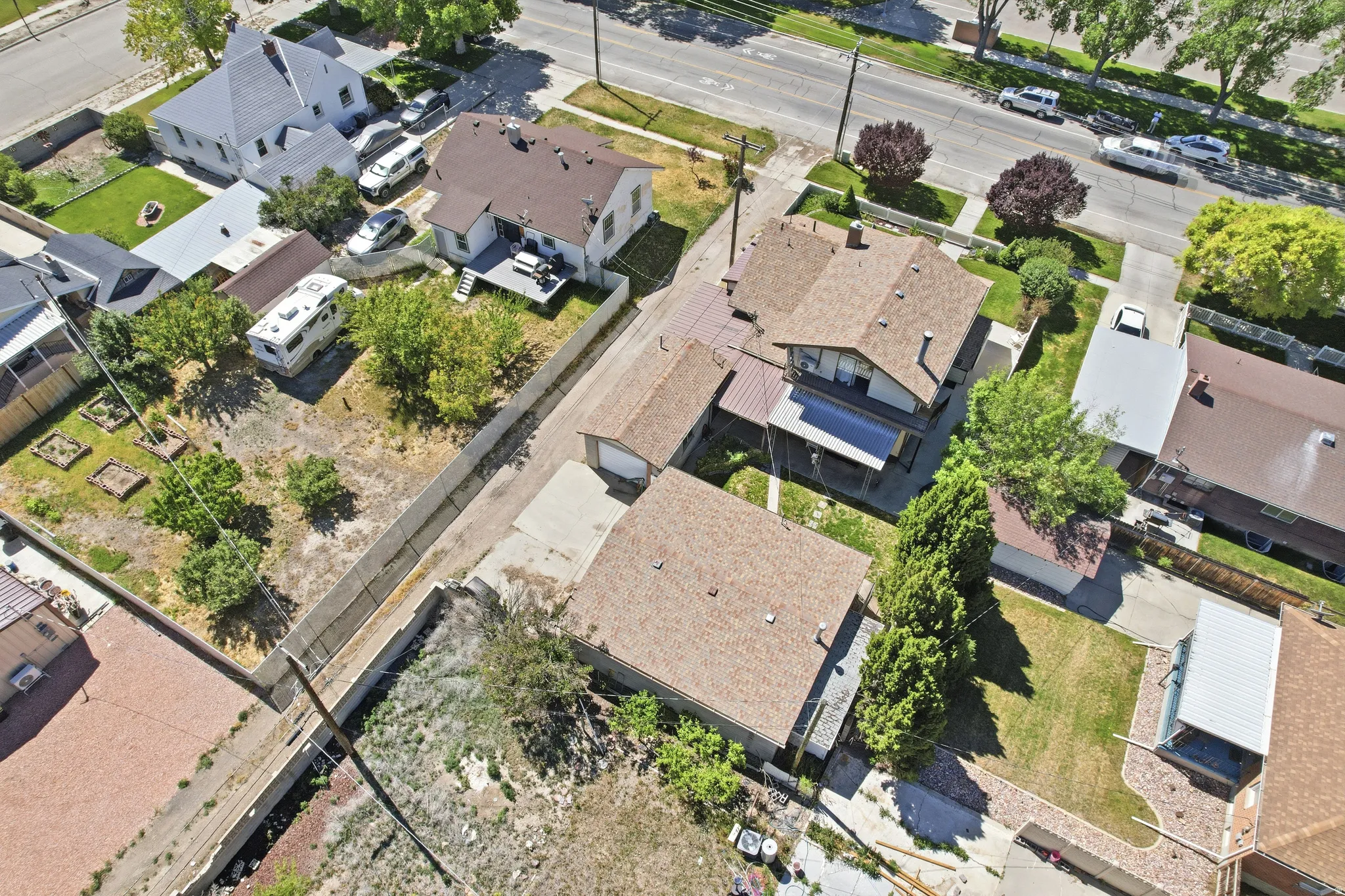 Aerial view showcasing multiple properties with pitched roofs, varied lot sizes, and established landscaping