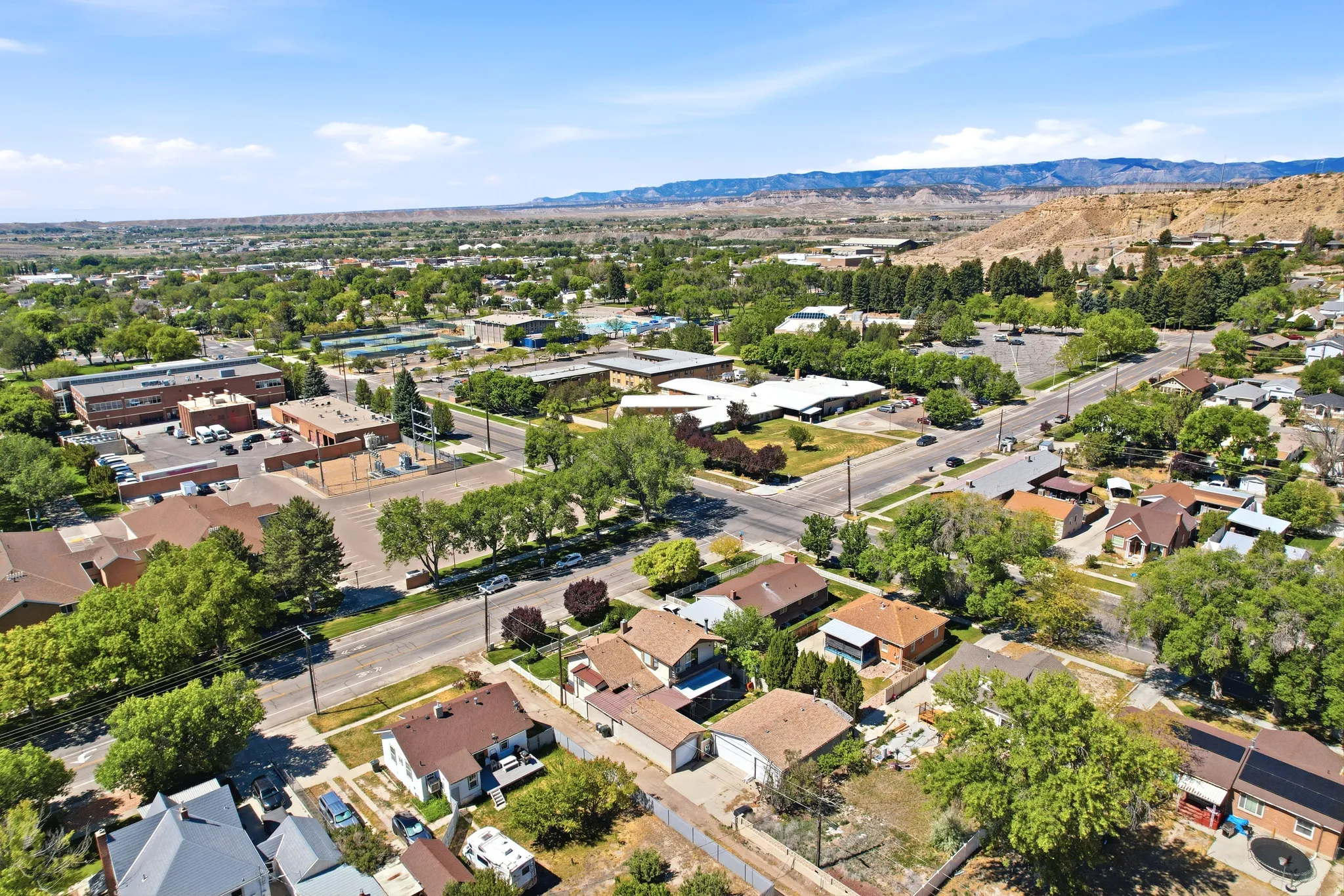 Expansive aerial perspective showcasing a residential neighborhood with mature trees and diverse architectural styles