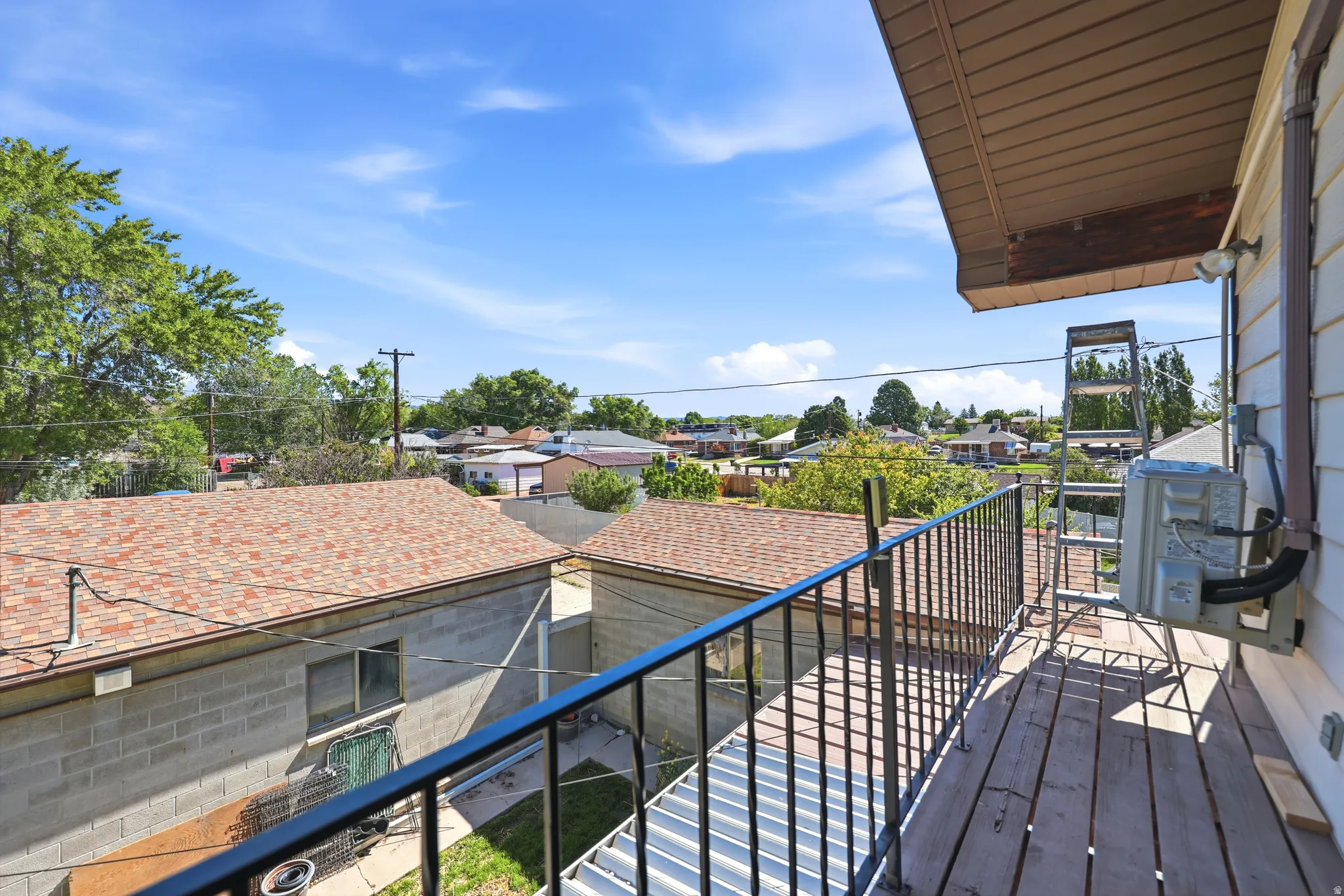 Balcony featuring wood-finish decking and black wrought iron railing