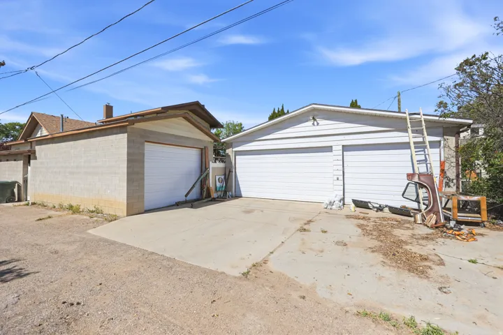 Two detached garages offering multiple vehicle storage, featuring a concrete block structure with a single garage door and a white siding structure with two garage doors