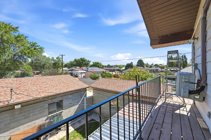 Balcony featuring wood-finish decking and black wrought iron railing